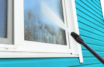 cleaning service washing building facade and window with pressure water